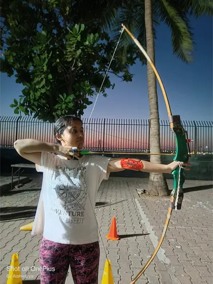 A student practices her shot, with the beautiful Mumbai sunset in the background.