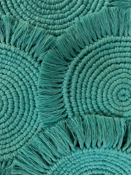 A close-up shot of the turquoise coasters, highlighting the tight, consistent knotting. This view shows the texture and craftsmanship that goes into each small piece.