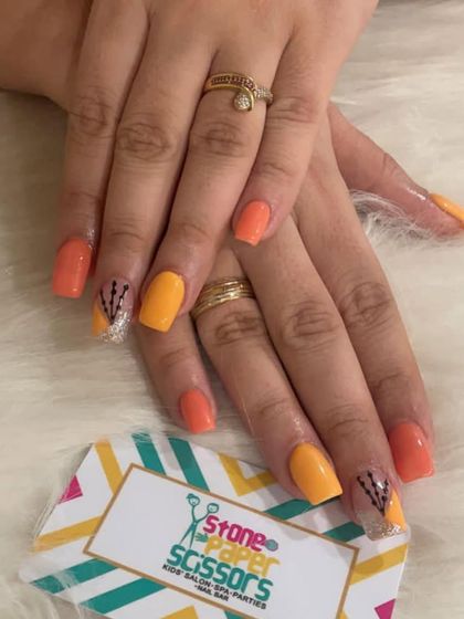 Bright and sunny nails featuring shades of orange and yellow. I added a touch of sparkle and a simple hand-painted design on an accent nail to complete the look.