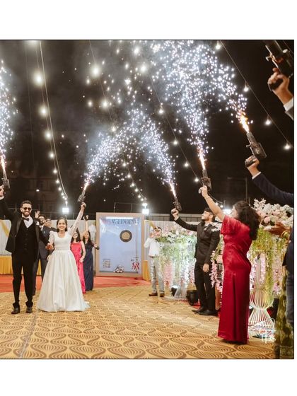 A show-stopping moment as the couple is welcomed with an arch of cold pyro guns held by their friends. This creates a high-energy, celebratory, and incredibly photogenic entrance.