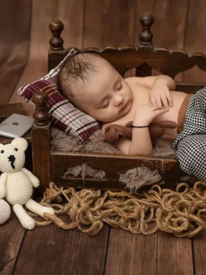 A different angle of the sleeping baby, showing off his cute checkered pants and the rustic wooden theme.