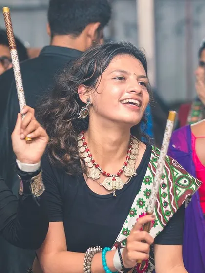 A smiling dancer with her dandiya sticks, lost in the rhythm of the Garba music. The joy and cultural pride at these events are infectious.