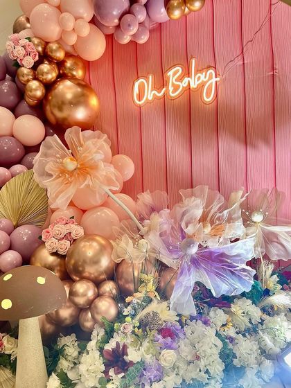 A close-up of the intricate details in the enchanted garden theme. You can see the sheer fabric flowers, small floral bunches, and a variety of balloon sizes and finishes that add depth and elegance.