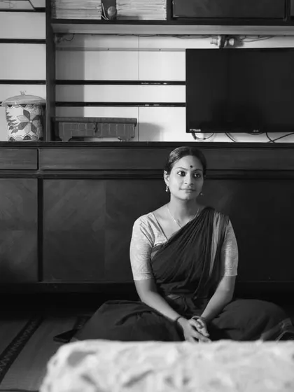 Capturing the artist in her environment. This wide shot shows Arundhati in her living room, grounding her art in the context of her everyday life.