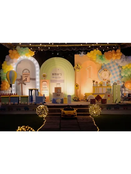 For the little one who loves all things that go, this transportation theme was a dream come true. This expansive stage setup features multiple illuminated arches, a mini-train, a ride-on car, and a hot air balloon, creating a bustling city of fun.
