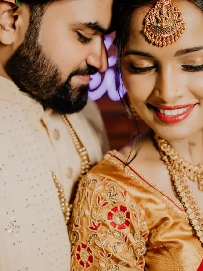 A close-up, intimate portrait of a South Indian couple. The bride's smile and the groom's gentle gaze create a moment of pure, serene love.