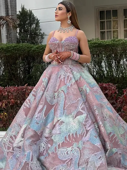 Our client looking absolutely radiant in her pastel-hued ball gown. The intricate patterns and shimmering fabric catch the daylight beautifully, making it a perfect choice for a daytime engagement ceremony or an outdoor photoshoot.
