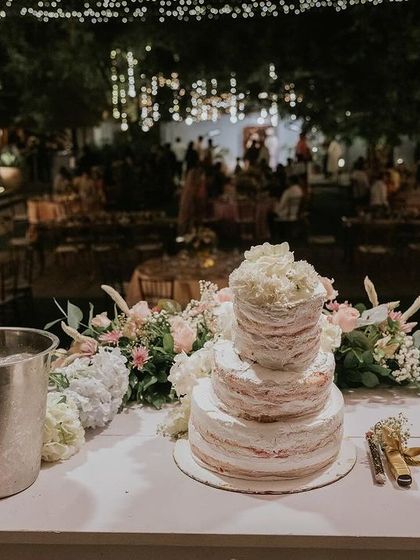 A beautiful tiered wedding cake and champagne ready for the reception, set against the backdrop of our venue lit up at night.
