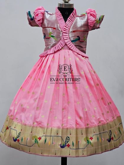 A lovely pink Pattu Pavadai with a Paithani border, paired with a jacket-style blouse with peacock motifs.