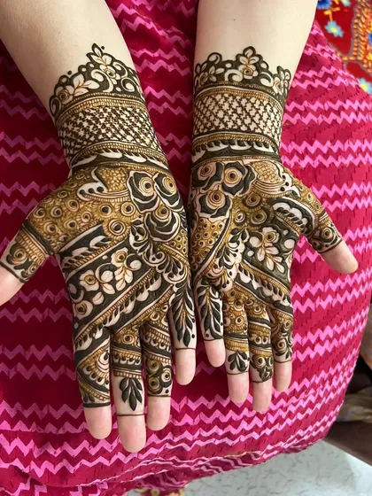 This bold Arabic mehndi design is a favorite for parties and sangeets. The contrast between the thick, dark lines and the delicate shaded floral patterns creates a very striking and modern effect on the hands.