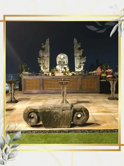 A stunning Balinese-themed bar setup for a rooftop party. The intricate stone statues and natural wood bar create a serene and exotic atmosphere, perfect for a sophisticated sundowner event with a view.
