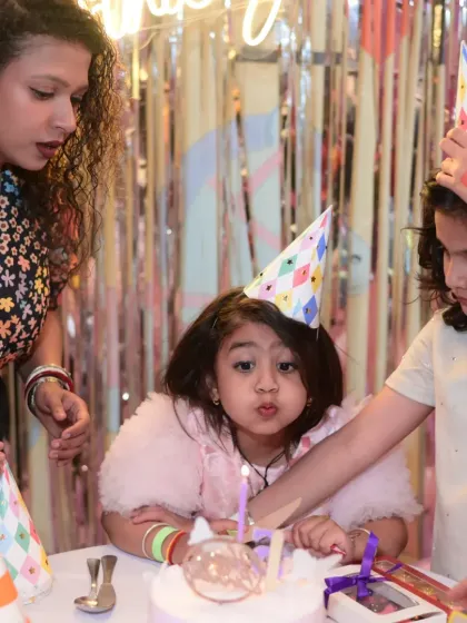 The birthday girl blowing out her candles, surrounded by family and friends. A classic and heartwarming moment.