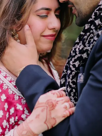 An intimate close up showing a tender moment between the couple. Capturing the delicate details, like the groom's touch and the bride's henna, adds depth to the story.