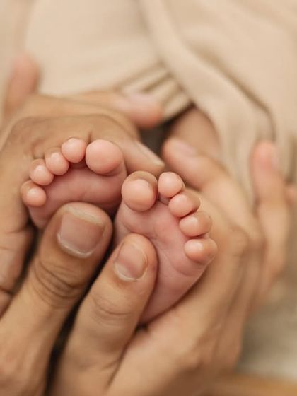 A father's hands gently holding his baby's tiny feet. A beautiful and sentimental portrait.