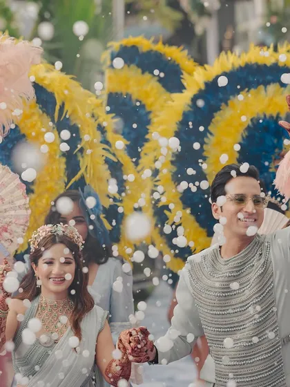 A close-up of the couple's happy faces, surrounded by bubbles and the vibrant colours of their carnival-themed welcome.
