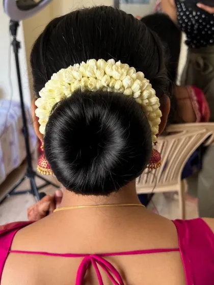 A classic bridal bun is timeless for a reason. This sleek, perfectly formed bun adorned with a traditional jasmine veni offers a look of pure elegance and is a specialty I teach in my masterclasses.