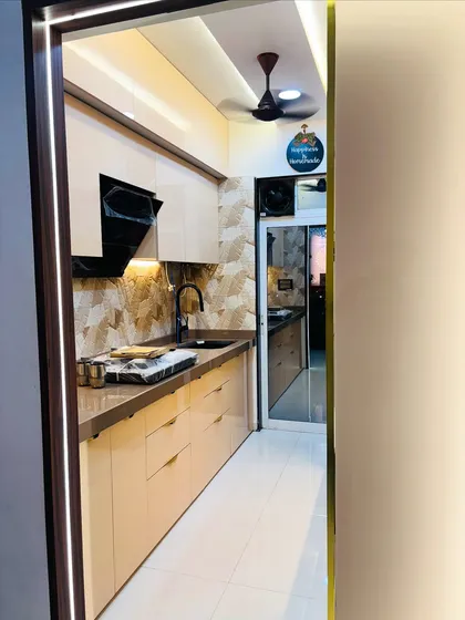 Another view of the beige kitchen, highlighting the seamless integration of the black sink and faucet with the countertop.