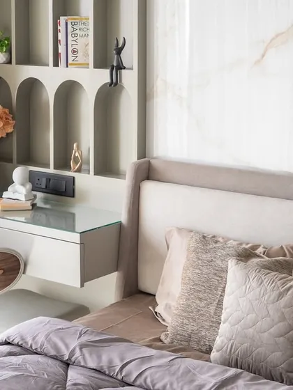 A tranquil corner that embodies quiet sophistication through a seamless blend of soft textures and architectural detailing. The custom arched shelving acts as both a functional display and a sculptural statement, finished in a muted olive-grey.