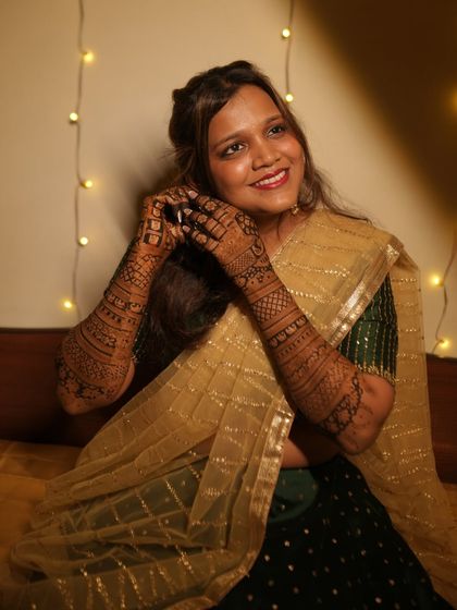 The glow of a bride-to-be. This candid shot captures her happiness, with her intricate mehendi adding to the charm.
