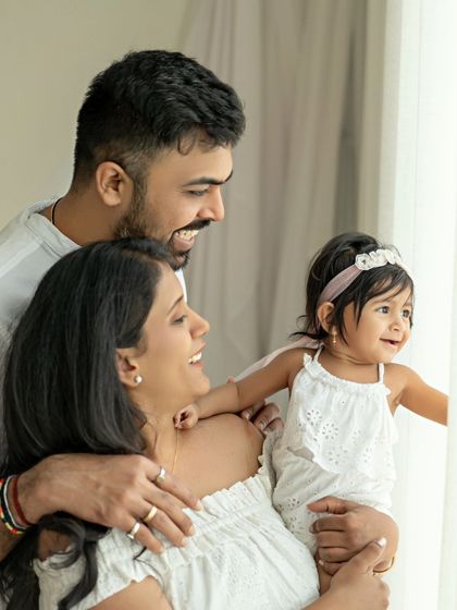 Uncovering the secrets of a happy life. This candid family portrait by the window captures a moment of shared joy and beautiful natural light.