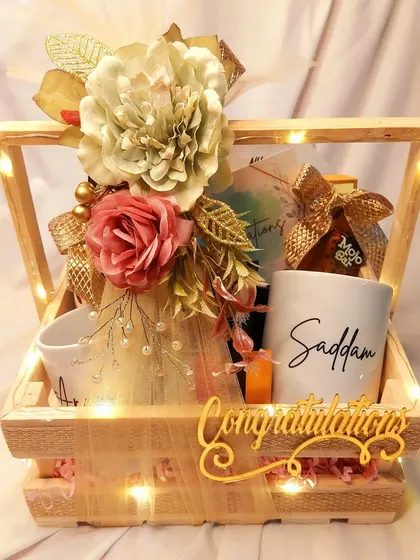 Celebrate the happy couple with this 'Congratulations' hamper. Packed in a rustic wooden crate, it features personalized mugs and other treats, all illuminated by our signature fairy lights.