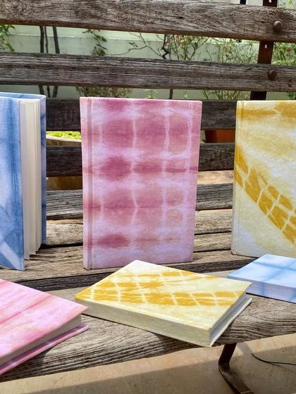 My collection of handmade notebooks. The covers are wrapped in beautiful, tie-dyed fabrics coloured with natural indigo, sappanwood, and marigold. They are available in both ruled and unruled versions.