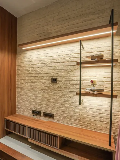 A TV unit with a white brick accent wall and industrial-style iron and wood shelving.