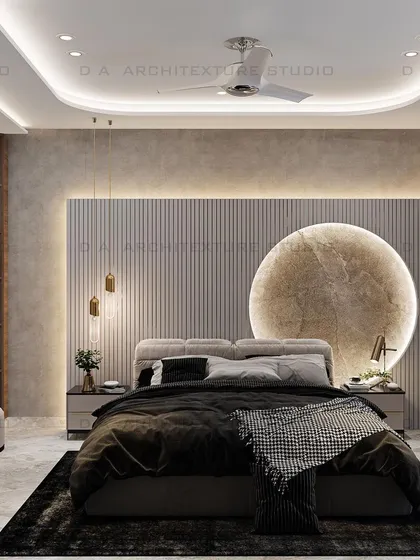This bedroom design for a project in Meera Bagh features a serene, beige-themed decor. The centerpiece is the custom, moon-shaped marble carving behind the bed, which adds a touch of artistry and serves as a unique focal point for this tranquil retreat.