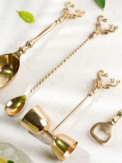 A flat-lay of an elegant, brass bar set, showcasing each piece of the collection in a beautifully arranged composition.