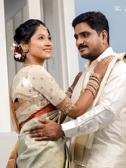 A bride in a light green and red Kanchipuram saree. Her custom off-white blouse features a unique back cutout and delicate embroidery.