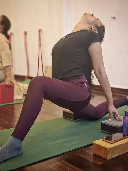 A student practices Hanumanasana (splits) with the support of yoga blocks to deepen the stretch safely.