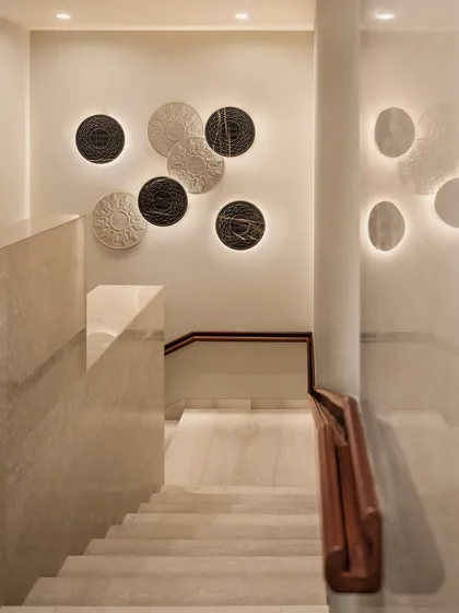 The staircase at the Elevate Clubhouse, featuring backlit wall art. This turns a simple circulation space into a gallery-like experience, enhancing the journey between floors.