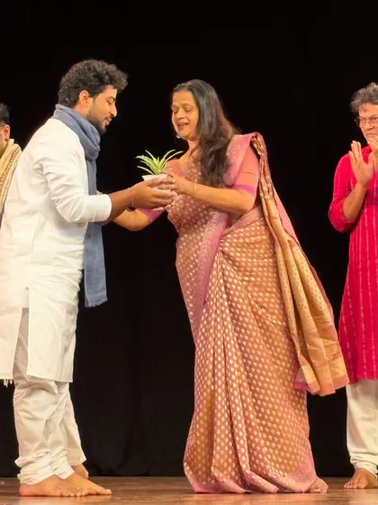 Being felicitated on stage after a successful dance show.