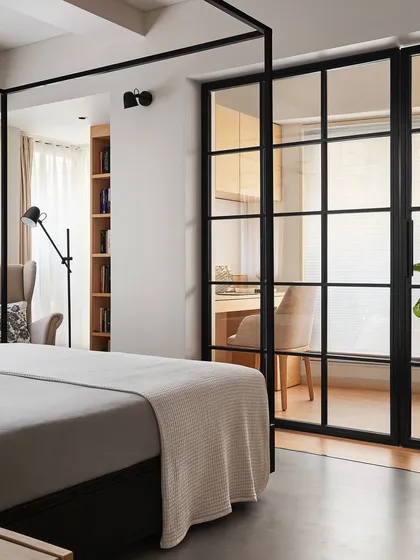 In this master bedroom, I designed a modern four-poster bed from black ash wood to create a strong focal point. The design balances a commanding presence with a minimalist feel, complemented by the transition from concrete to wood flooring that defines the adjacent study area.