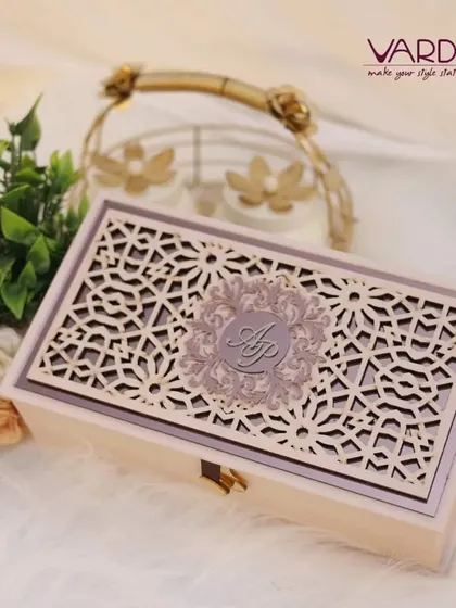 An elegant wooden invitation box featuring an intricate laser-cut lid with a custom monogram. This design combines natural materials with sophisticated craftsmanship, perfect for holding invitations and dry fruits or other special treats.