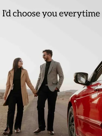 A candid moment of the couple walking hand-in-hand on an empty road, with the front of their red convertible adding a pop of color.