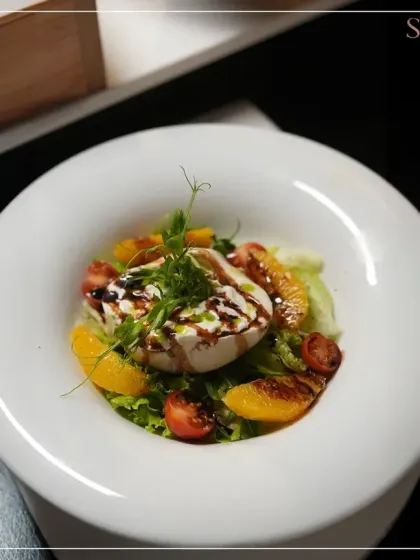 A fresh and vibrant salad with grilled burrata, oranges, and tomatoes, finished with a balsamic glaze. A perfect example of our light yet luxurious salad creations.