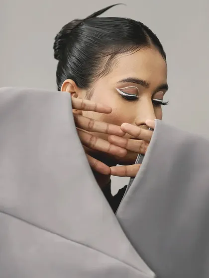 A sharp, white graphic liner provides a stark, beautiful contrast against the skin. This look is all about clean lines and minimalist impact.