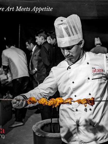 Where art meets appetite. This black and white shot captures one of our chefs skillfully preparing kebabs in a tandoor, highlighting the passion and artistry behind our food.