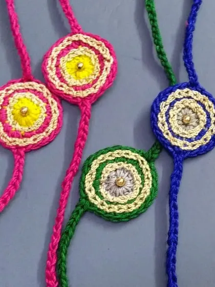 A vibrant assortment of our classic round crochet rakhis. Each one is made with colorful threads and a central bead, offering a simple and traditional option.