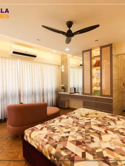 An overview of a master bedroom designed with an elegance of simplicity. The room includes a built-in dressing table and display cabinet, parquet flooring, and soft, ambient lighting.