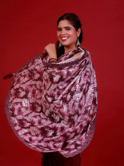 The swirl of a saree captured in motion. This shot is full of life and energy, showcasing the beautiful drape and sparkle of the fabric against the bold red.