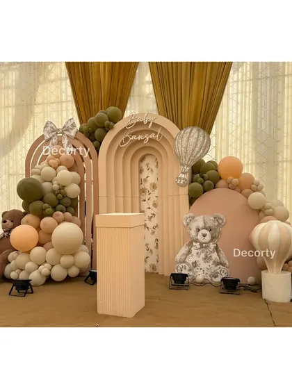 A full view of the elegant, neutral-toned backdrop with multiple arches and teddy bear details.