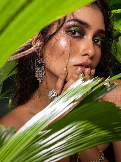 Peeking through the leaves, this artistic shot creates a sense of mystery while highlighting the diamond jewelry.