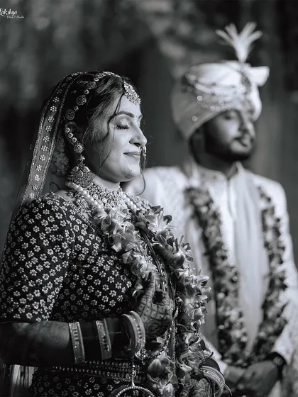 A serene black and white photo taken during the ceremony. The bride's peaceful expression as she soaks in the moment, with her groom in the background, creates a timeless and emotional image.
