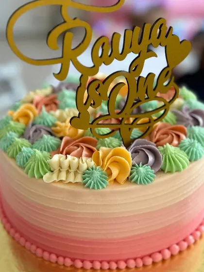A beautiful custom cake for a first birthday. This Belgian dark chocolate cake is encased in my signature American buttercream in lovely ombre hues of pink.