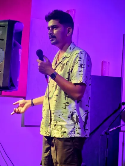 A comedian engaging the audience during a candlelit show. We welcome all kinds of performers, and the supportive crowd ensures everyone, including first-timers, has a great experience.