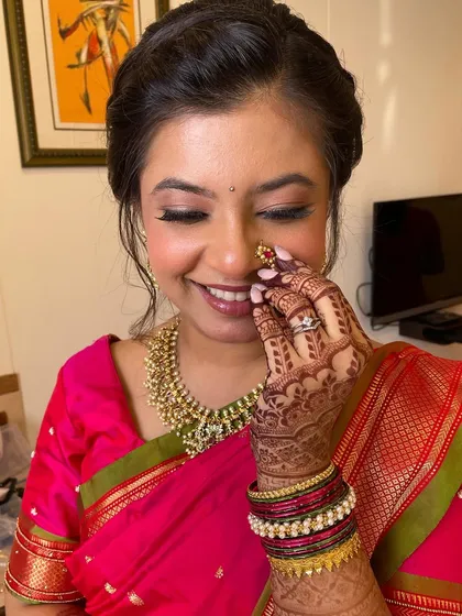 A fresh and youthful Marathi look. The bride's smile says it all. The makeup is light, with a focus on rosy cheeks and a natural lip color.