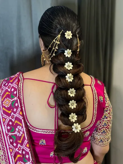 Another angle of the floral pull-through braid, showcasing the craftsmanship and how each accessory is perfectly placed. This is a great Indian bridal braid style for long hair.
