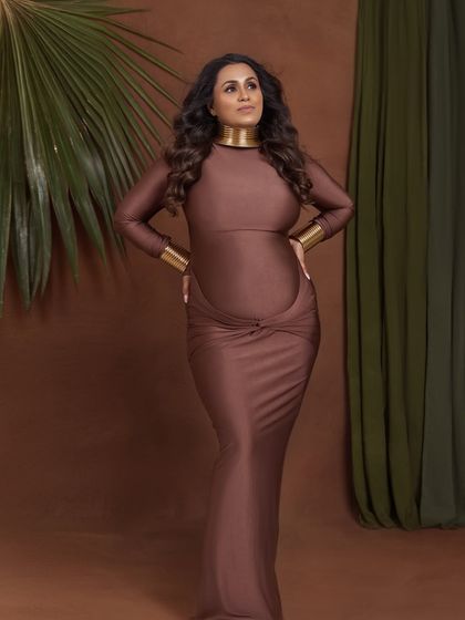 A confident, full-length pose that showcases her strength and the beauty of her pregnancy.